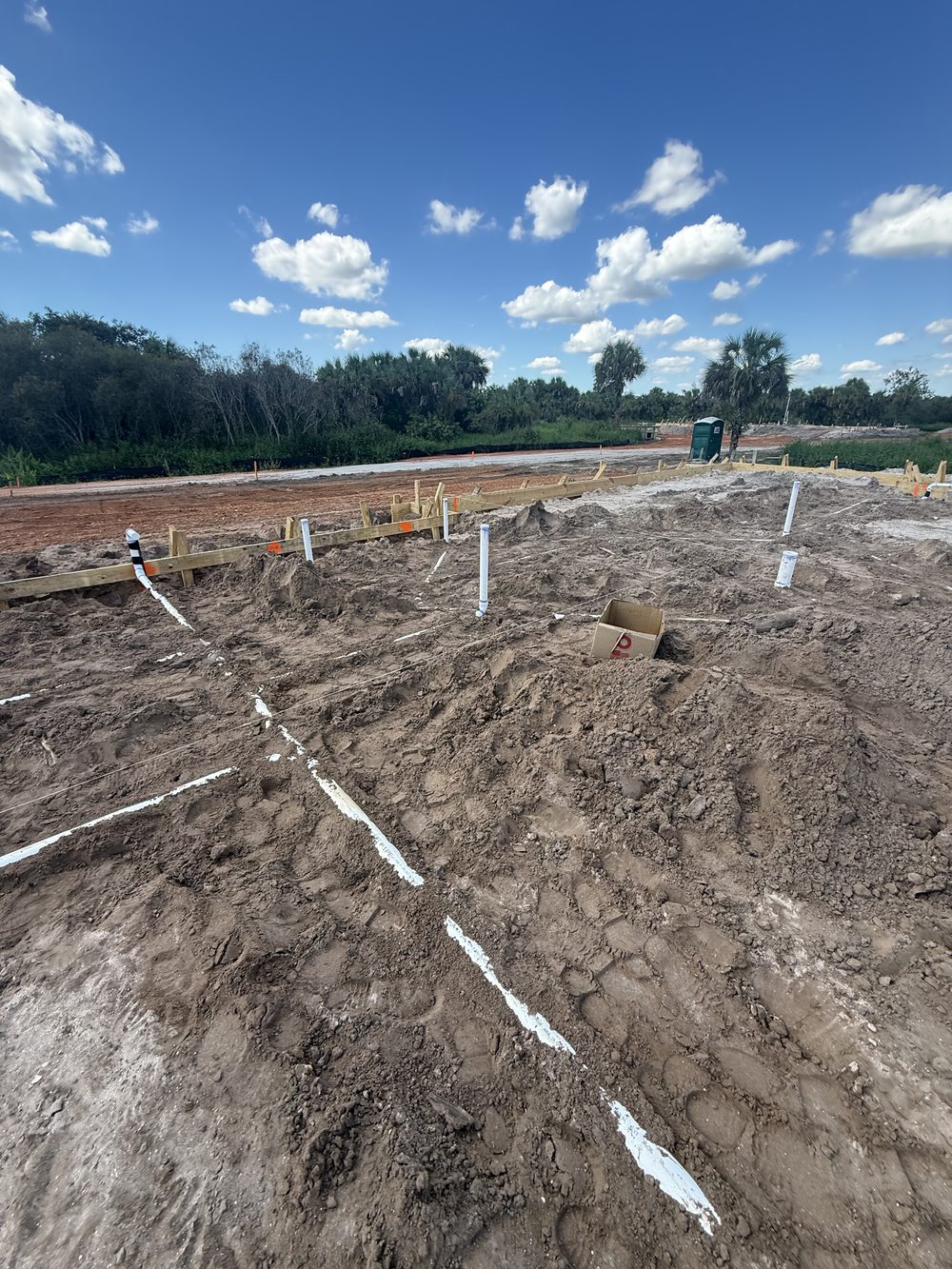 Formed foundation pad with rough plumbing stub-outs on the Riddle family's Golden Gate Estates build, ready for inspection